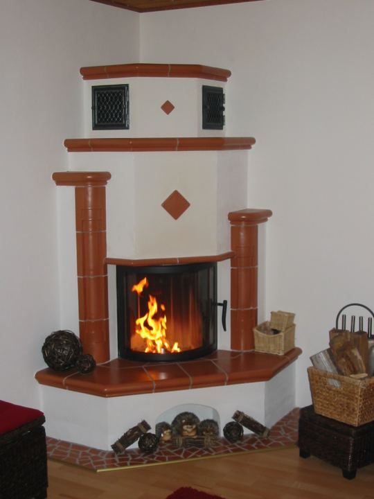 Eck-Heizkamin mit Terrakotta-Kacheln und Feuer