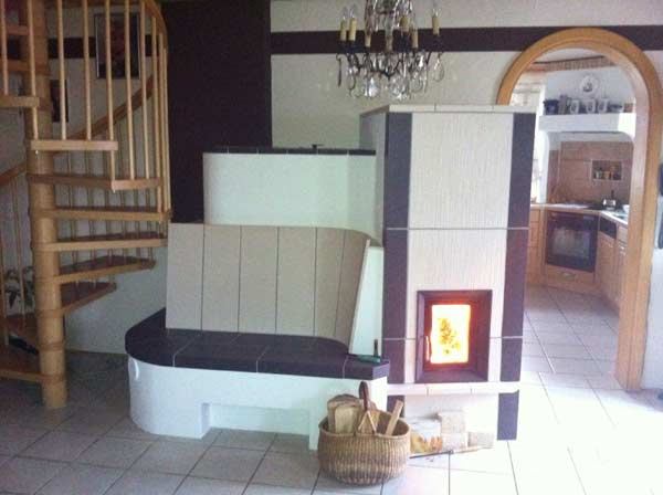Kachelofen mit Ofenbank neben einer Wendeltreppe